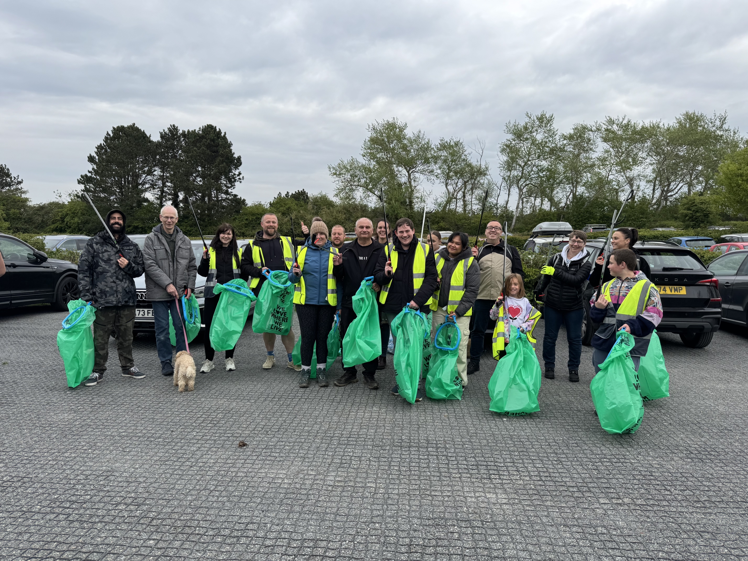 Volunteers standing on an EcoGrid reinforced parking area during an Earth Day coastal clean-up event