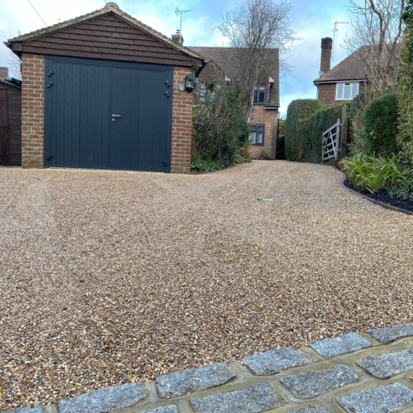 Completed permeable gravel driveway reinforced with EcoGrid outside a residential property