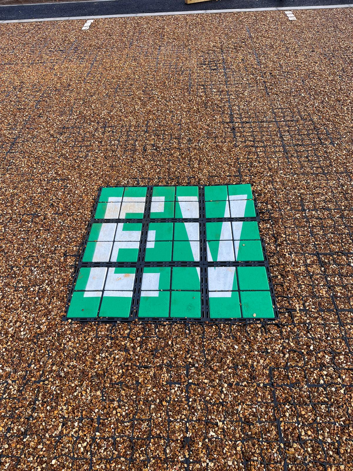 EcoGrid Bloxx EV charging bay marking installed in a permeable gravel car park