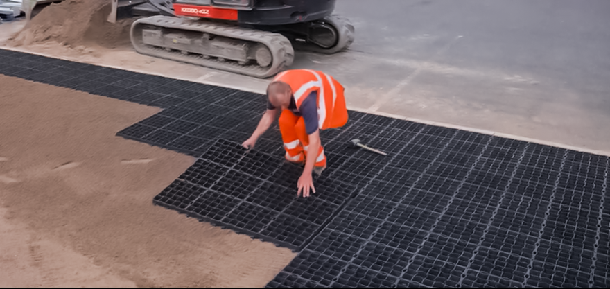 Start safety & EcoGrid yard installation - man laying EcoGrid
